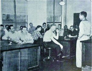 Students sit in forestry class overseen by their instructor, circa 1949.