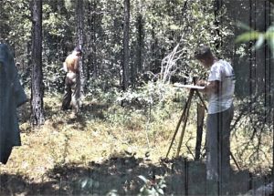 One man records ecology information on a canvas-like structure at summer camp, circa 1948.