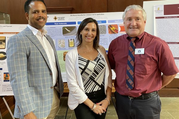 Left to right: Curry, Peresin, and Enebak stand in front of poster research presentations.