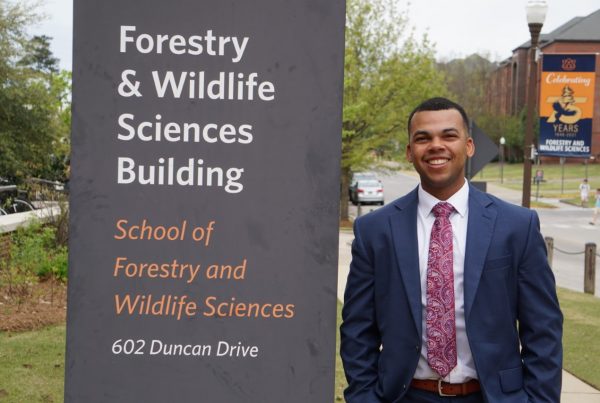 Turner stands next to the Forestry & Wildlife Sciences Building signage.
