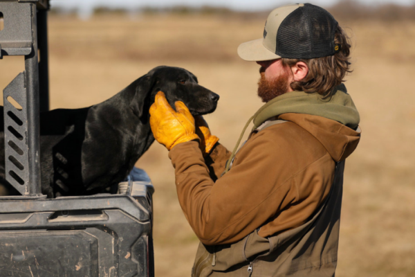 Travis Black with a dog during a waterfowl hunt