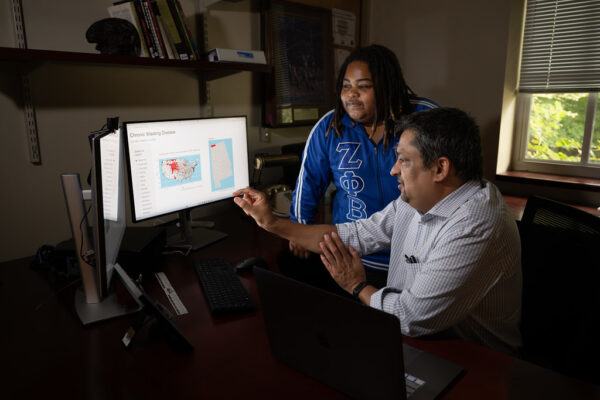 Ani Belsare is pictured with student Kayla Alston reviewing Belsare’s chronic wasting disease computer model.