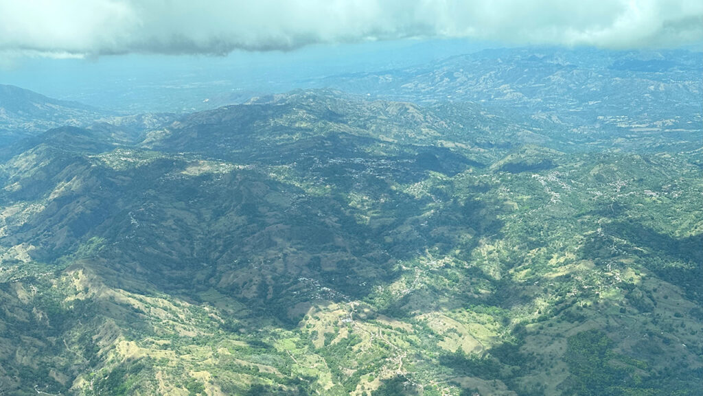 An aerial view of fragmented forest land in a mountainous region.