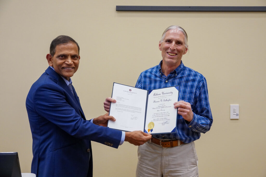 Tom Gallagher receives a certificate from Emmett F. Thompson Dean of the CFWE, Janaki Alavalapati.