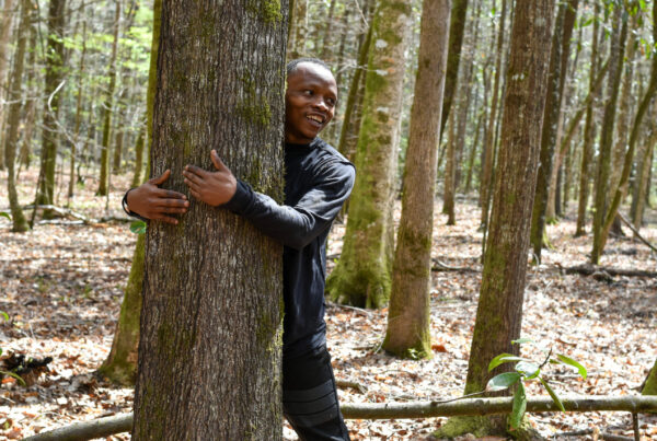 Abubakar Tahiru embraces a tree while attempting his world record tree-hugging goal.