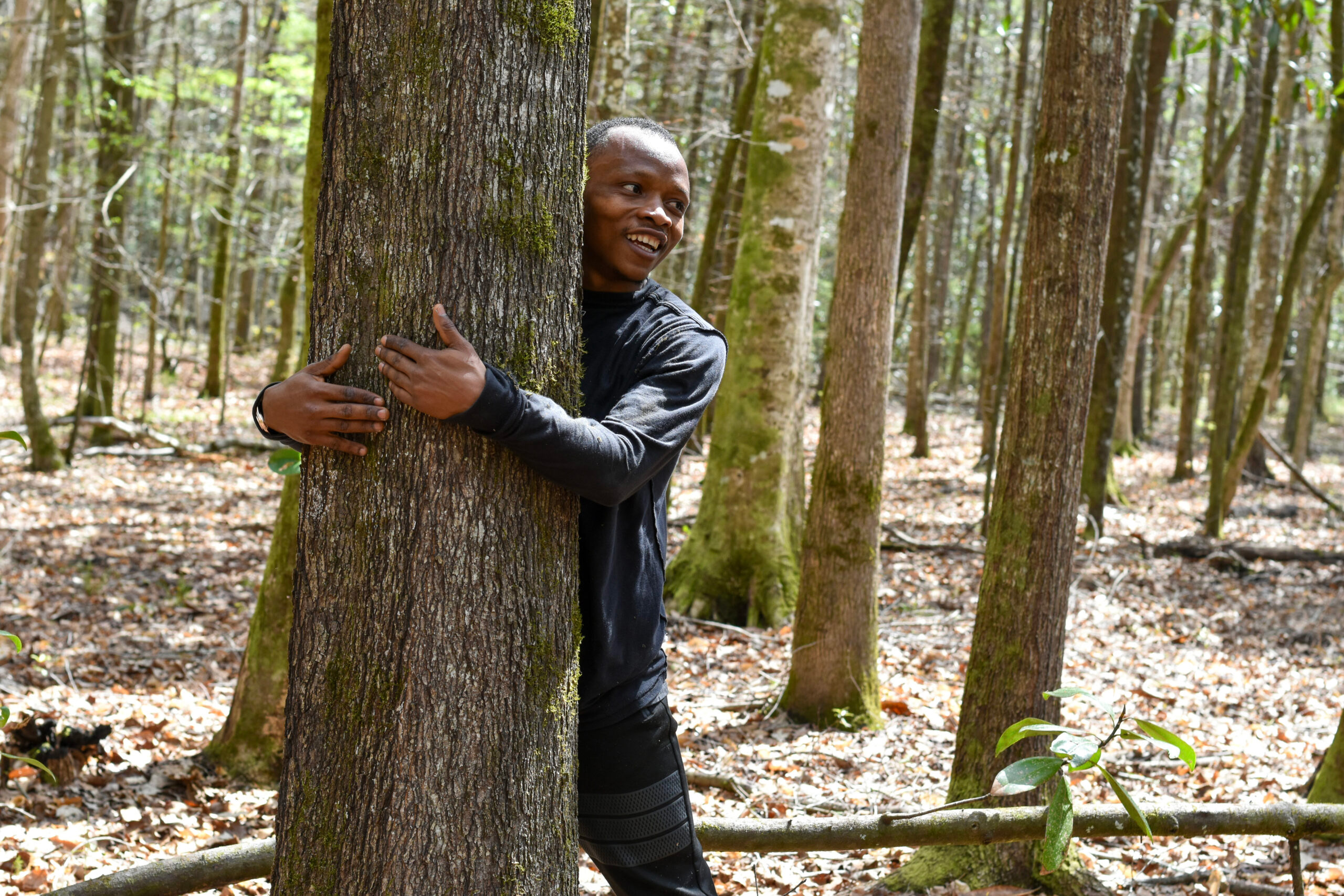 Abubakar Tahiru embraces a tree while attempting his world record tree-hugging goal.