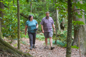 Jean Fantle-Lepczyk (left) and Chris Lepczyk (right) walk down a trail while discussing wildlife research.