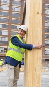 Man hugging thick wooden post.