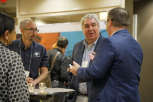 A group of forestry professionals speak together during a reception at the 2024 Auburn University CLT conference.