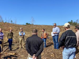 Matt Ezekiel facilitates a field tour to an investor group in a clear cut forest stand.