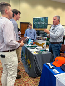 Matt Ezekiel speaks with CFWE students at a career fair.