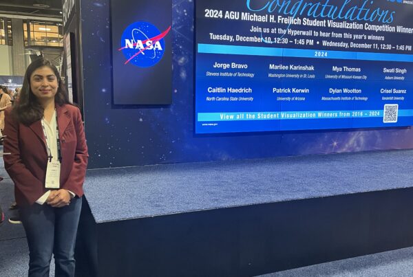 Woman standing next to a stage after winning a prize.