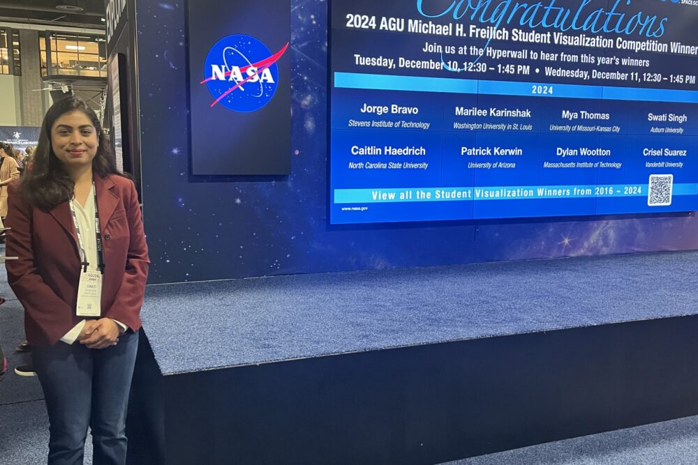 Woman standing next to a stage after winning a prize.