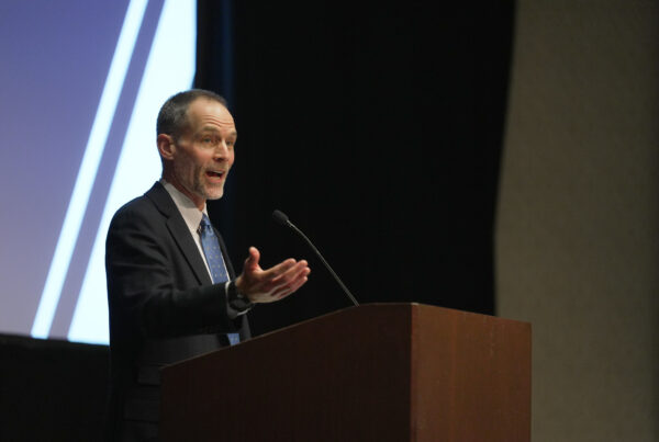 Brooks Mendell speaks from a podium to an audience at The Auburn University Hotel and Dixon Conference Center.