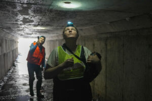 Molly Simonis searches for bats in a manmade culvert using a headlamp.