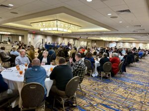 A room full of people listening to a speaker
