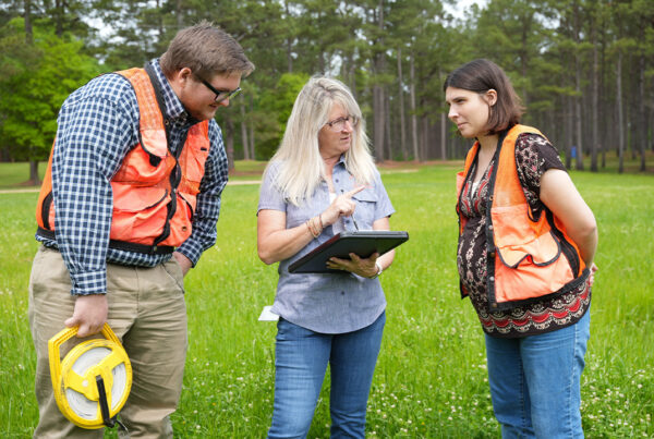 Woman in the middle is teaching two students.