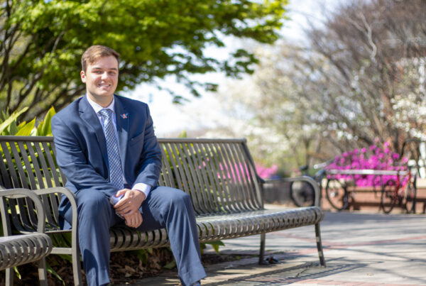 Thomas Davis poses for a photo while sitting on a bench on Auburn University's campus.