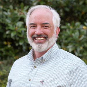 Jim Noles standing in front of a wood-grain backdrop