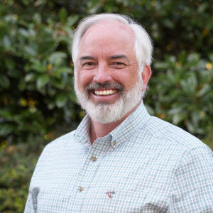 Jim Noles standing in front of a wood-grain backdrop