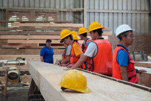 A group of students gather in a wood mill 