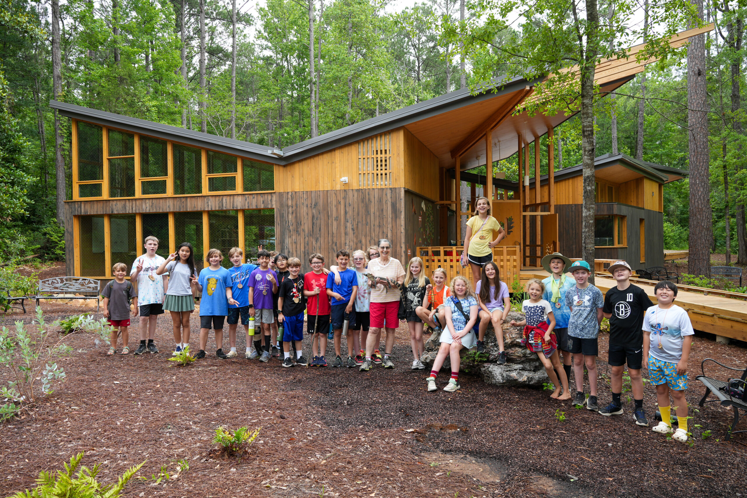 Emily Kling poses with reptiles and Summer Ecology Camp students in front of the Environmental Education Building at the KPNC.