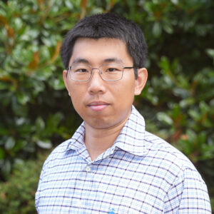 Yang Yang poses for a headshot against a green background