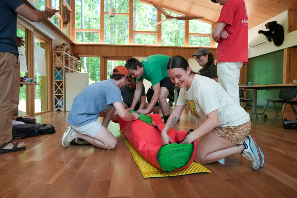 students perform wilderness first aid on a fellow class participant