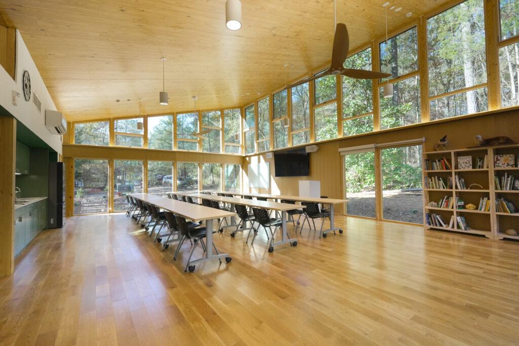 classroom with tables, chairs, bookcase and windows