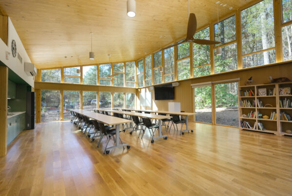 classroom with tables, chairs, bookcase and windows