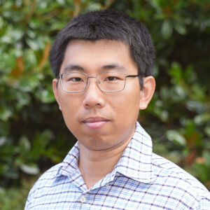 Yang Yang poses for a headshot against a green background