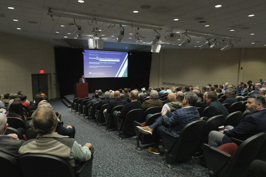 man giving remarks at podium in auditorium