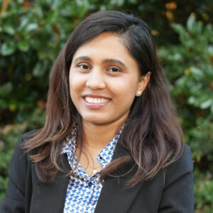 Mandira Pokharel poses for a photo headshot against a green background.