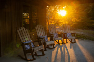 The sun sets over the River Bank and Trust front porch at Crooked Oaks