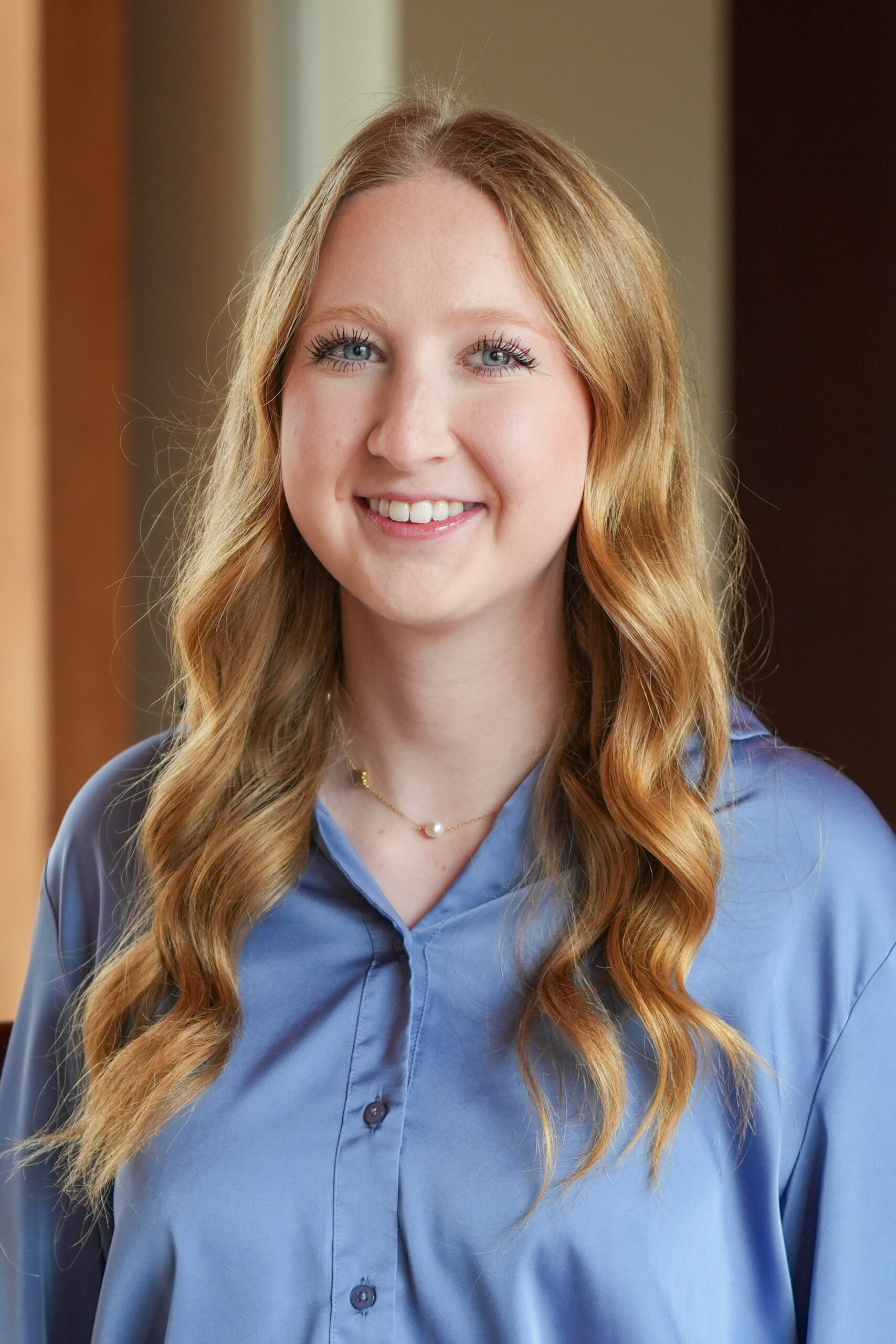 Lillian Avis standing in a blue shirt smiling.