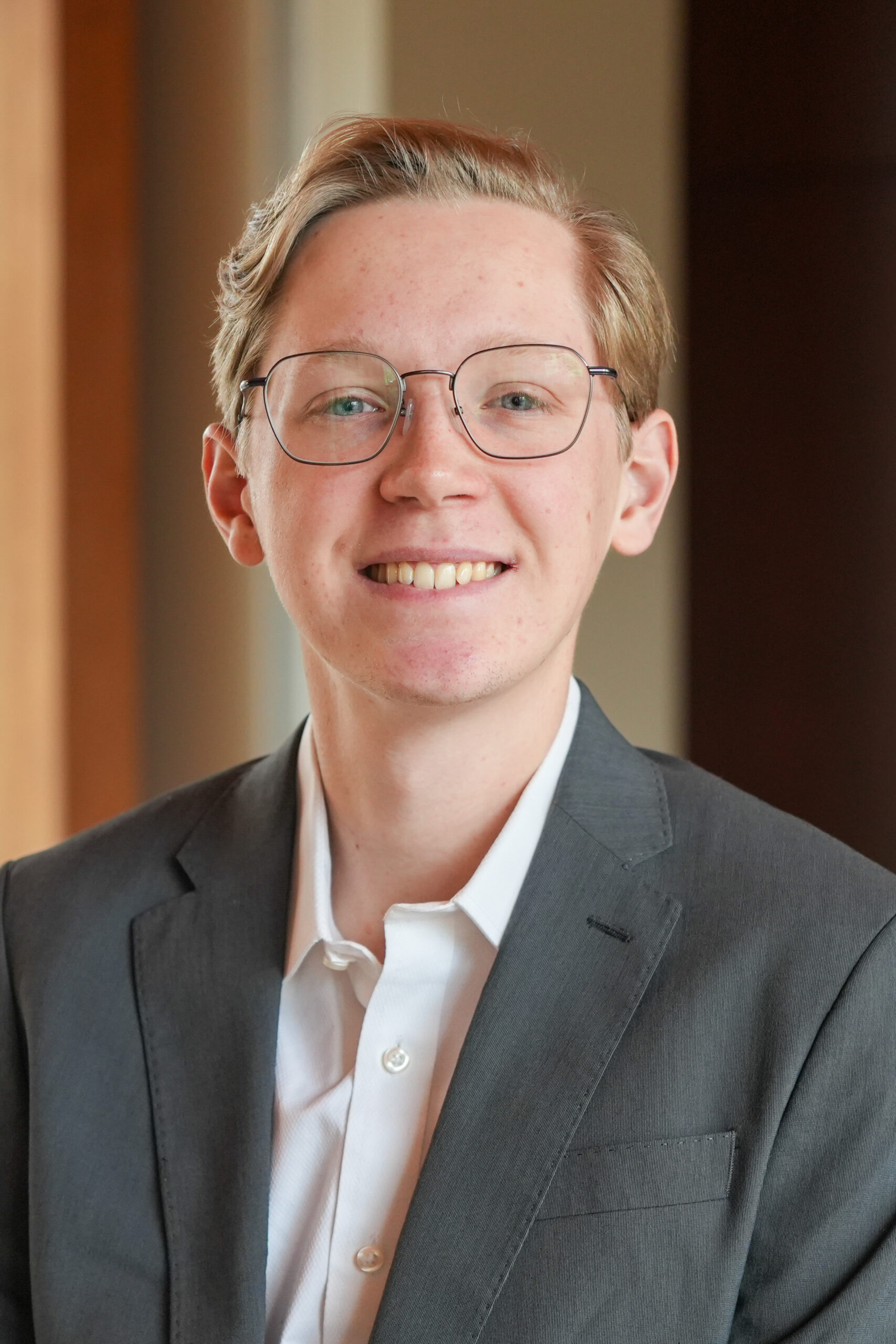 William 'Ketch' Daniel standing in a grey suit jacket smiling.