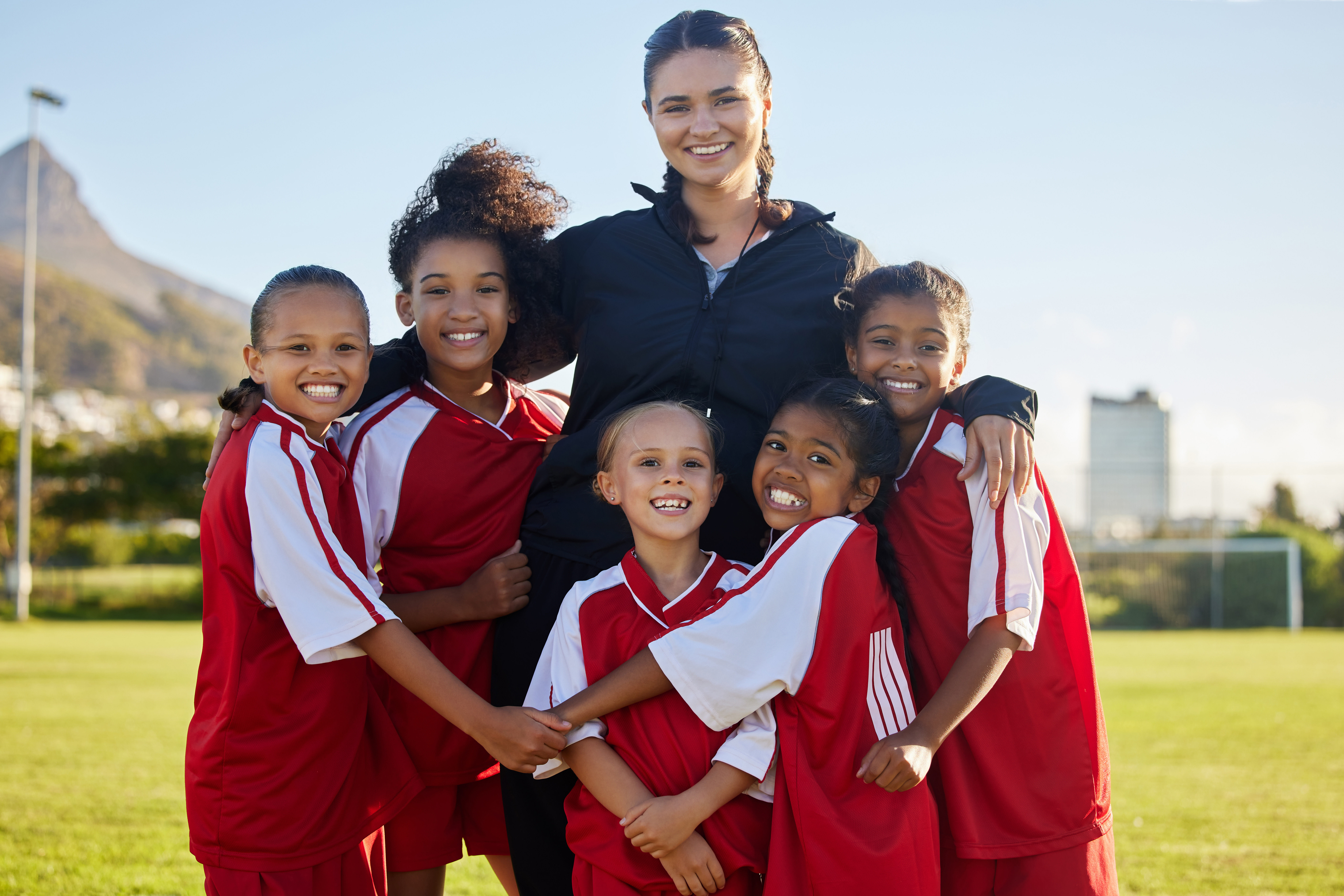 female sports league coordinator with players seen on a sports field