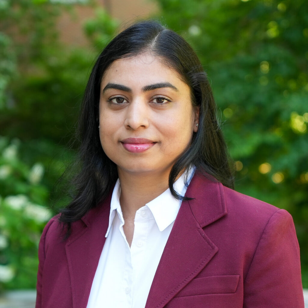 Swati Singh poses for a headshot against a forested background