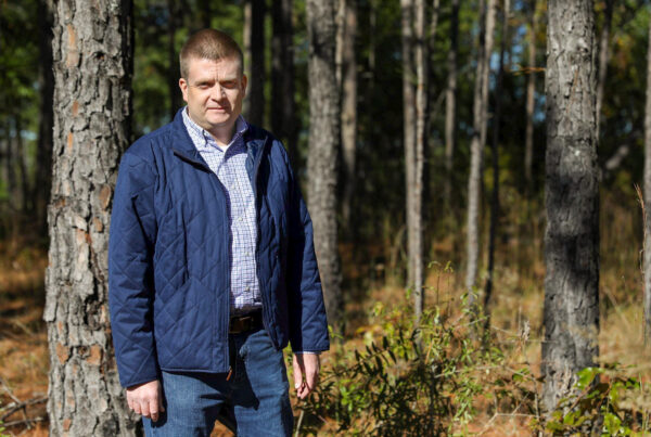 James Parker poses for a photo in a forest
