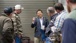 Yucheng Peng holds up a bio-based product during a stakeholder research tour.