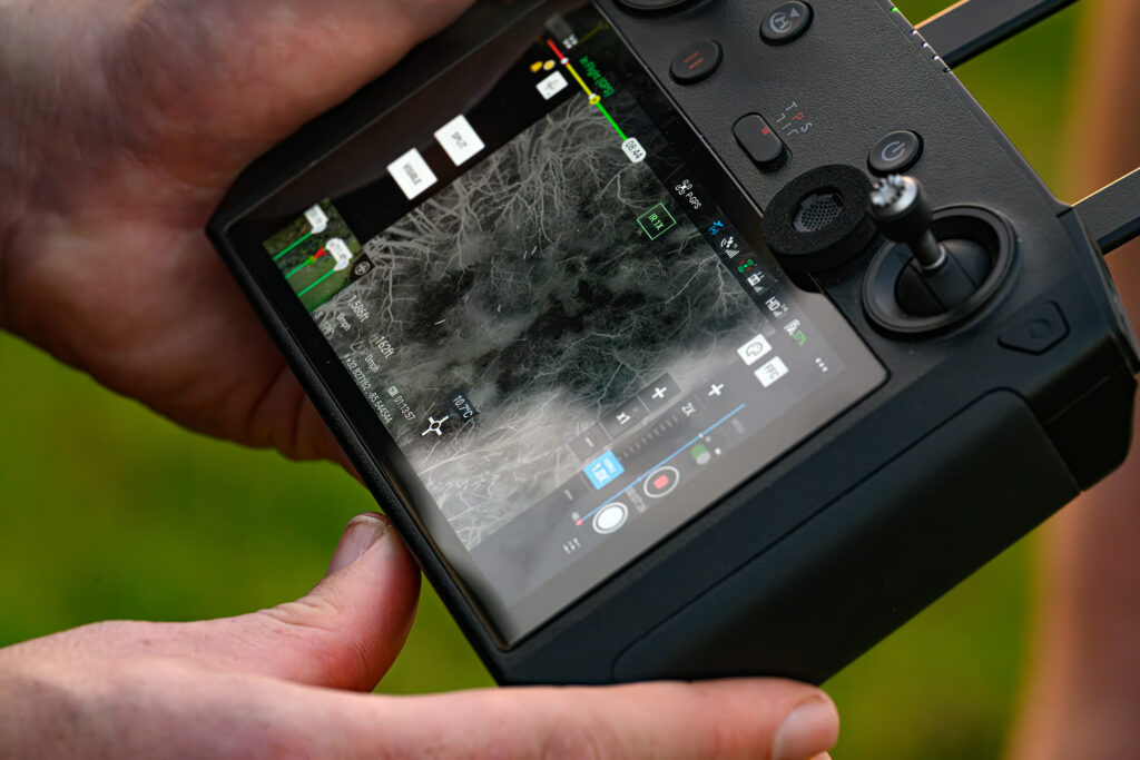 person holding drone equipped with thermal videography