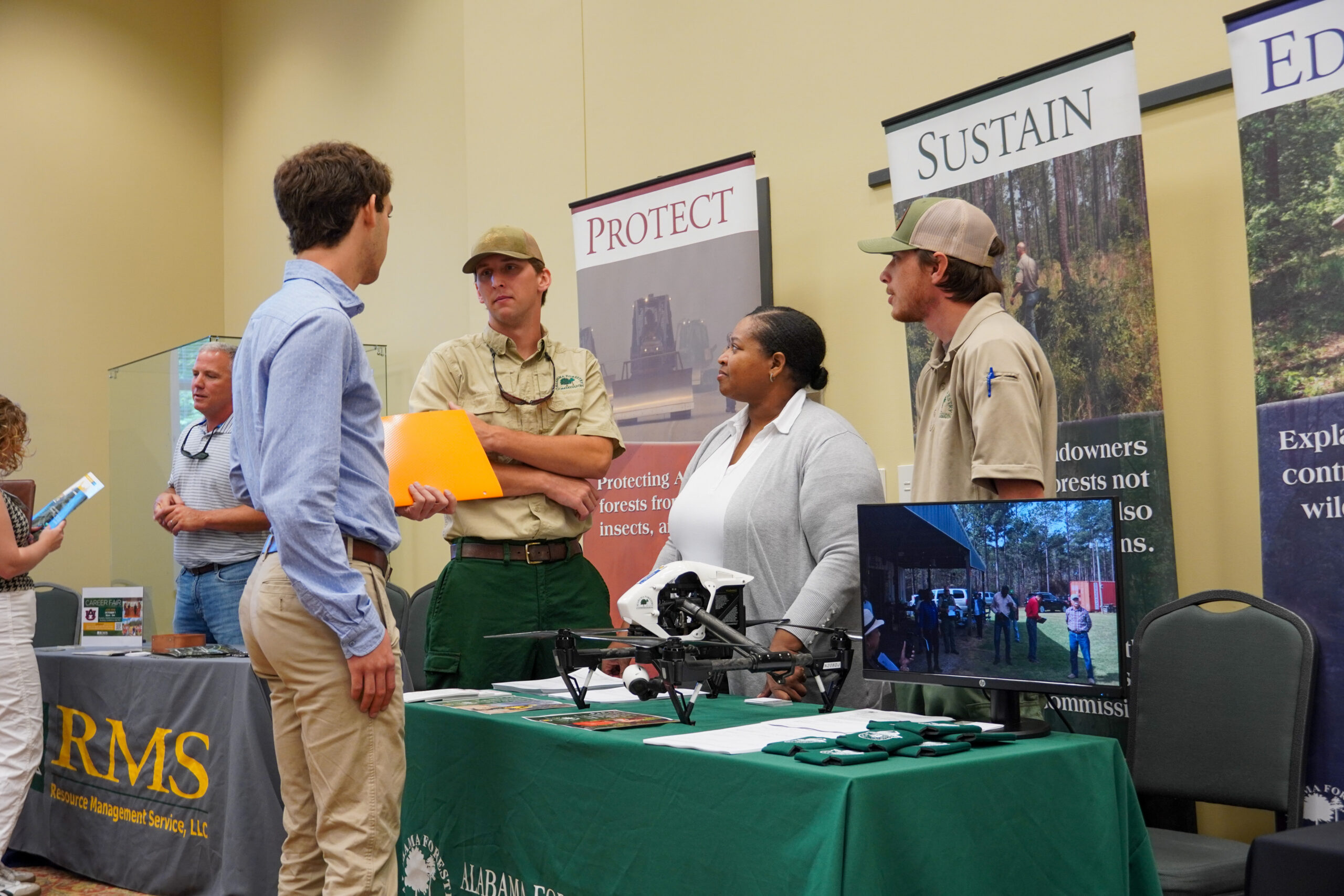 Student speaks to three people at an exhibit space during career fair