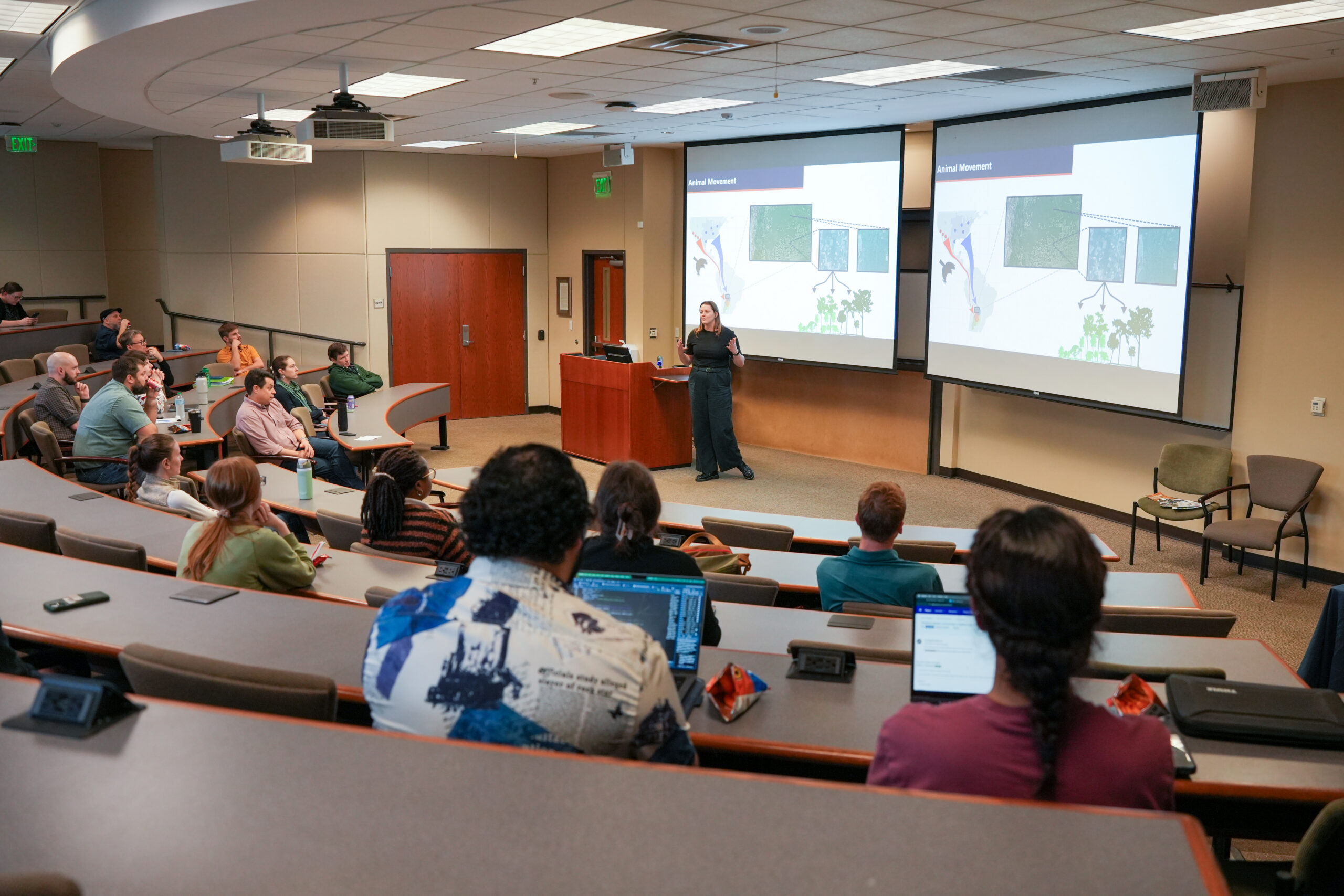 A CFWE Seminar featuring a room full of an audience and a gues speaker.