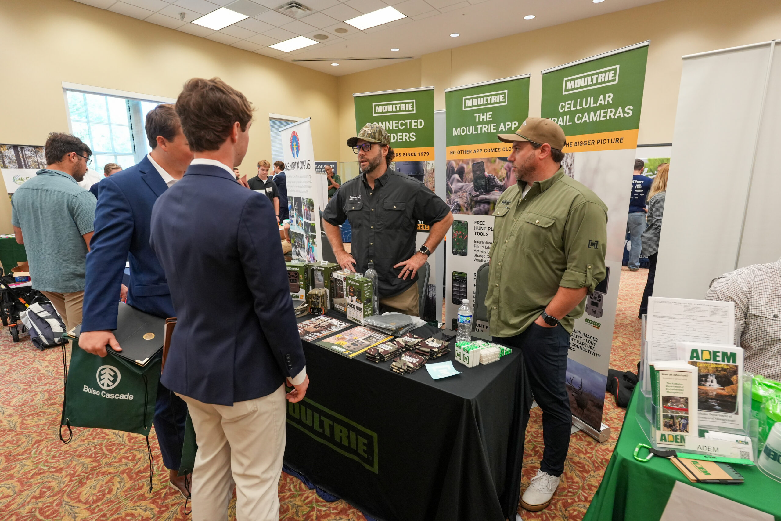 two male students speak with an employer