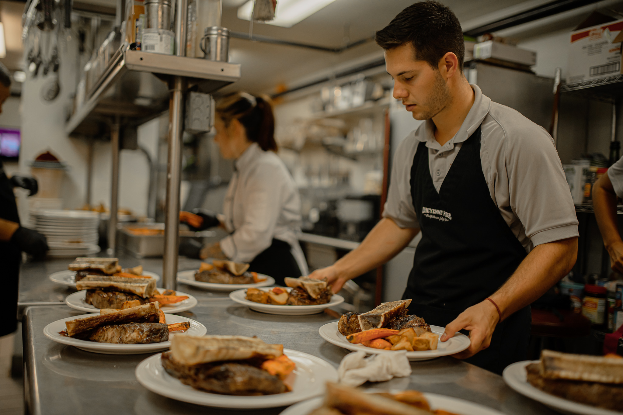 intern prepares food in lodge kitchen for guests