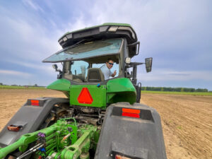 Harris Crumpton operates a tractor in a crop field
