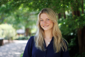 Gracie Carlile poses for a headshot portrait in a shady area on Auburn University's campus.
