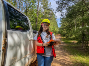 Matalynn Padgett next to truck in pine forest
