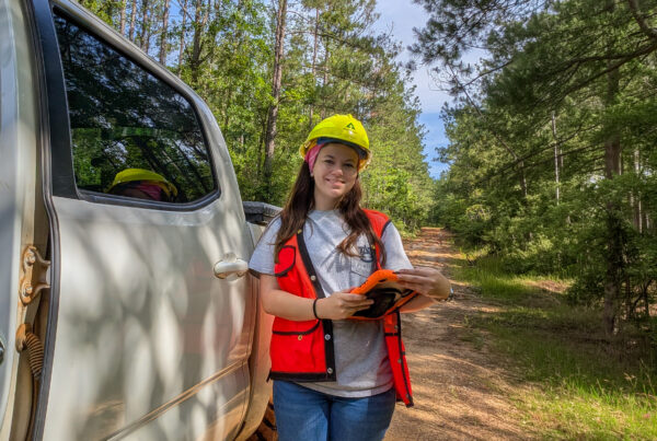 Matalynn Padgett next to truck in pine forest