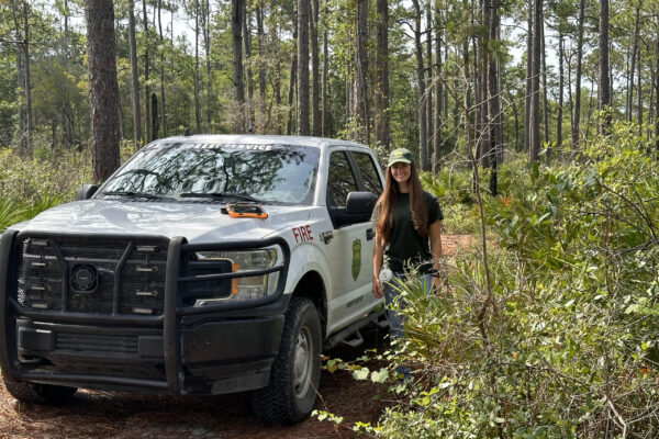 Anna Warren standing next to white work truck